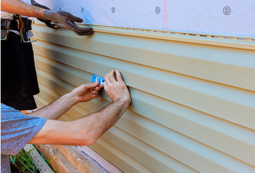 Workers adjusting house siding panels