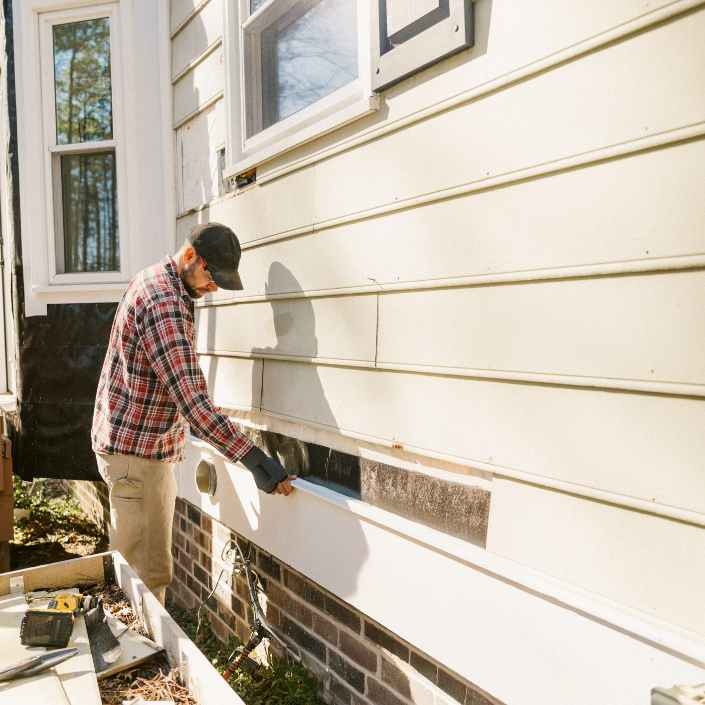 Construction worker repairing a house siding